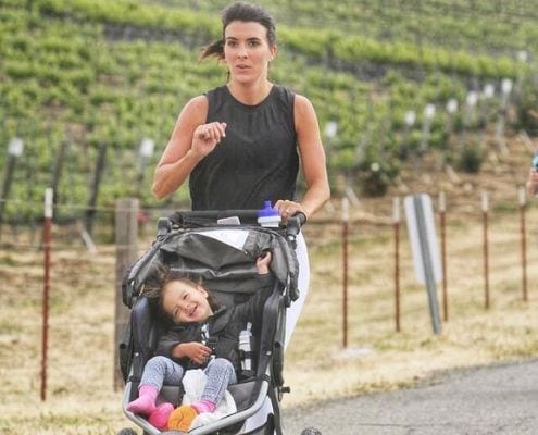 Samantha pushing her daughter in a jogging stroller, building their unbreakable bond.