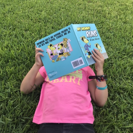 A child reads My Mommy Runs, a children's book about running.