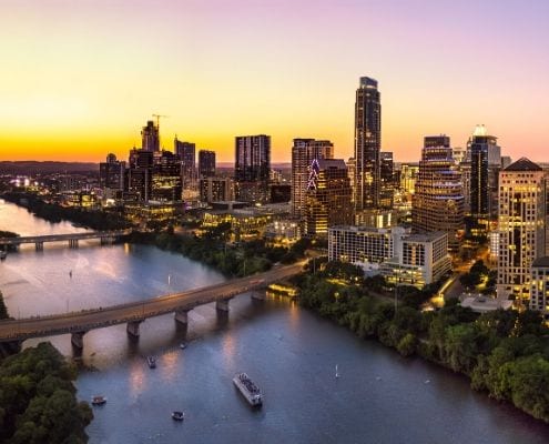 Drone image of downtown Austin and the sunset. Runners can get a good night's sleep and stay near the Austin Marathon start and finish lines when they book their downtown Austin hotel with with the Hotels for Hope booking platform.