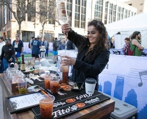 Image of a bartender pouring a drink with Tito's Handmade Vodka at the 2019 Austin Marathon Hilton VIP Experience.
