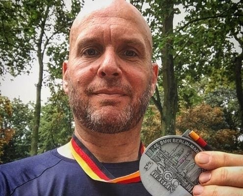 Image of Jonathan Acott showing off his medal from the Berlin Marathon. Read about his journey to run the world and how the Austin Marathon is next!