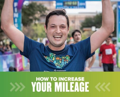 Image of male runner with his hands raised in the air in celebration after crossing the 2019 Ascension Seton Austin Marathon. Design on the image contains text that reads How to Increase Your Mileage.