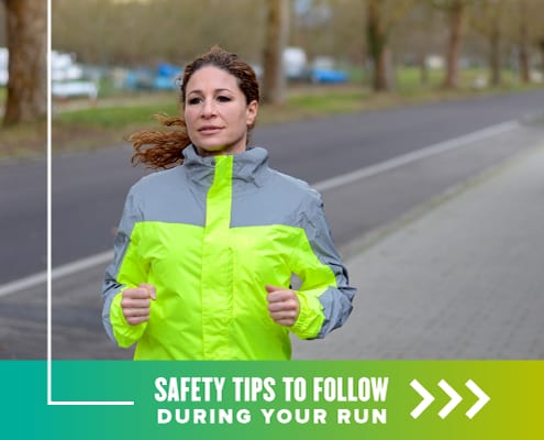 Female runner runs on the road against traffic wearing a bright yellow high-visibility jacket. Text on design reads Safety Tips to Follow During Your Run. Read more at http://48d.435.myftpupload.com/running-safety-tips/