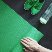 Hand rolling green yoga mat with sneakers Hand rolling green yoga mat with sneakers