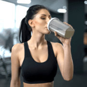 Woman drinking from protein shaker bottle