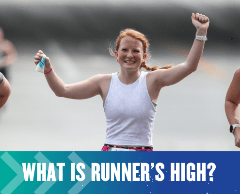 A smiling woman with red hair is running with her arms raised in celebration, likely experiencing the runner's high. She is wearing a white sleeveless top. Other runners are partially visible in the background. Text at the bottom of the image reads, "What is runner’s high? Austin Marathon Half Marathon & 5K