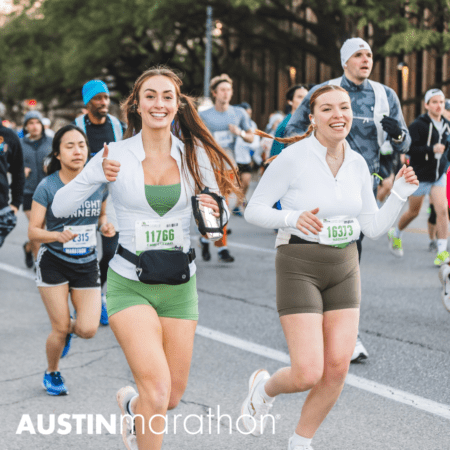 Two women, wearing athletic gear and bib numbers 11766 and 16313, smile and run in a marathon in Austin. The woman on the left gives a thumbs-up. Other runners are visible in the background. "Austin Marathon" is written at the bottom of the image, dispelling any marathon myths with their joyful presence.
 Austin Marathon Half Marathon & 5K