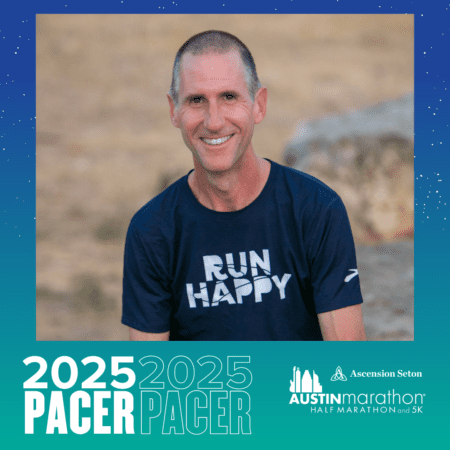 A smiling man with short hair is wearing a navy blue "Run Happy" t-shirt. He is sitting outdoors with a blurred background of grass and rocks. The image features text: "Meet Your 2025 PACER" and the "Austin Marathon Half Marathon and 5K" logo. Austin Marathon Half Marathon & 5K