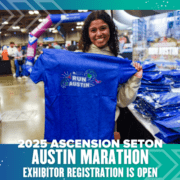 A person smiling and holding a blue "Run Austin" T-shirt at the Health & Fitness Expo during the 2025 Ascension Seton Austin Marathon. Text on the image reads: "2025 Ascension Seton Austin Marathon. Exhibitor registration is open. Austin Marathon Half Marathon & 5K