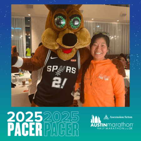 A woman smiles while posing with a person in a mascot costume wearing a Spurs jersey. The image, framed by a graphic for the 2025 Austin Marathon and 5K, showcases the text "2025 PACER" alongside the Ascension Seton logo, highlighting proud support from Pacer Group. Austin Marathon Half Marathon & 5K