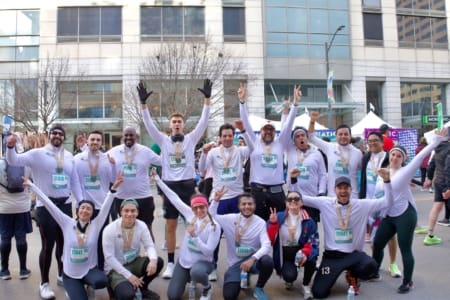 A group of marathon runners wearing white shirts and medals pose excitedly together outdoors, raising their hands and smiling after finishing a race—showcasing team management skills—with city buildings in the background. Austin Marathon Half Marathon & 5K A group of marathon runners wearing white shirts and medals pose excitedly together outdoors, raising their hands and smiling after finishing a race—showcasing team management skills—with city buildings in the background. Austin Marathon Half Marathon & 5K
