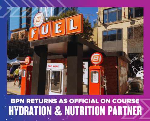 A BPN Fuel hydration and nutrition station with bright orange signage is set up outdoors in a city for the Ascension Seton Austin Marathon. Text below reads: "BPN returns as official on course hydration & nutrition partner. Austin Marathon Half Marathon & 5K