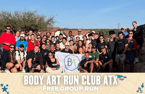 A large, diverse group of people pose together outdoors, smiling and holding a "BA" flag. Below them, text reads: "Body Art Run Club ATX - Free Group Run." Join Body Art’s welcoming ATX run club with trees and rooftops in the background. Austin Marathon Half Marathon & 5K