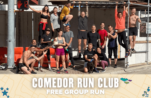 A diverse group of runners from Comedor Run Club poses and smiles outdoors, some standing, others sitting or playfully hanging from scaffolding. A banner below announces a free group run with colorful, decorative graphics. Austin Marathon Half Marathon & 5K