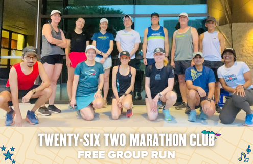 A group of 14 runners, dressed in athletic gear and sneakers, pose and smile together outside a building. Text at the bottom reads: "Twenty-Six Two Marathon Club Free Group Run" with decorative icons, highlighting this free group run event. Austin Marathon Half Marathon & 5K
