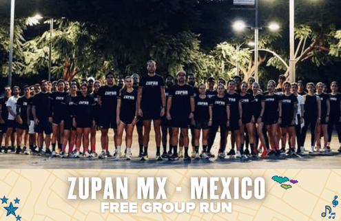A large group of people in matching black "ZUPAN" shirts pose outdoors at dusk under streetlights. Text overlay at the bottom reads, "ZUPAN MX - MEXICO FREE GROUP RUN," celebrating a spirited ZUPAN MX free run event. Austin Marathon Half Marathon & 5K