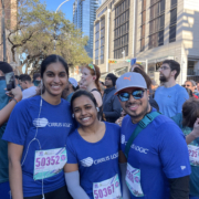 Three runners in blue shirts smiling at race Three runners in blue shirts smiling at race