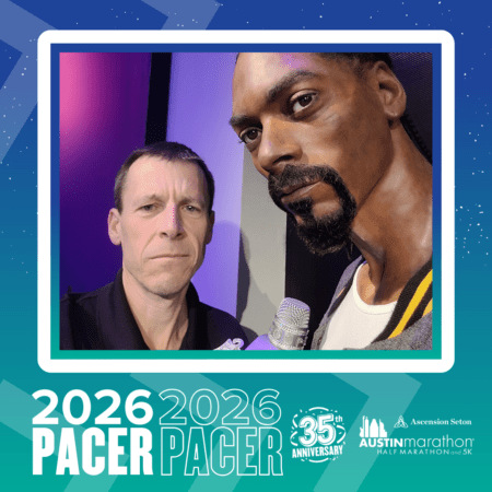Two men pose for a selfie; one is holding a microphone. The image has a turquoise border with text reading
