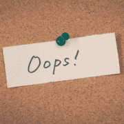A corkboard with a white note pinned by a green pushpin. The note has "Oops!" written in large, casual black letters—a lighthearted reminder that even marathon training or base building can have its unexpected moments. Austin Marathon Half Marathon & 5K