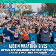 A large, diverse group of smiling marathon runners poses at the starting line in Austin. Text reads: “Austin Marathon Gives Opens Applications for 2027 Charity Partner Program.”. Austin Marathon Half Marathon & 5K