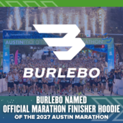 A large crowd of runners gathers at the Austin Marathon start line, with the BURLEBO logo proudly displayed alongside text announcing BURLEBO as the official Marathon Finisher Hoodie for the 2027 Austin Marathon. Austin Marathon Half Marathon & 5K