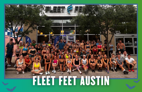 A large group of people in athletic wear poses and smiles outside the Fleet Feet Austin store, surrounded by trees, with “Fleet Feet Austin” text at the bottom, capturing the lively spirit of a South Austin Group Run. Austin Marathon Half Marathon & 5K