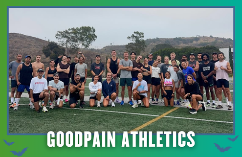A large group of people pose together on an outdoor sports field in South Austin, smiling and wearing athletic gear. Trees and hills appear in the background. Text at the bottom reads “GOODPAIN ATHLETICS — Rise and Run Group Run.”. Austin Marathon Half Marathon & 5K
