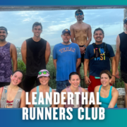 Nine sweaty runners, smiling and posing under a stone arch with greenery behind them after a spirited group run. Most are wearing running gear and hats. The words “LEANDERTHAL RUNNERS CLUB” appear at the bottom, with a blue border and bat silhouettes, capturing the energetic spirit of Austin’s running community. Austin Marathon Half Marathon & 5K