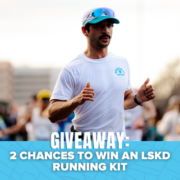 A man running in a race, wearing a white shirt and cap, is featured in the image. The text at the bottom reads, “GIVEAWAY: 2 CHANCES TO WIN AN LSKD RUNNING KIT.” Blue graphics and blurred runners set the background, emphasizing your opportunity to win exclusive prizes—don’t miss out on this exciting giveaway!. Austin Marathon Half Marathon & 5K