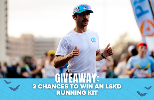 A man running in a race, wearing a white shirt and cap, is featured in the image. The text at the bottom reads, “GIVEAWAY: 2 CHANCES TO WIN AN LSKD RUNNING KIT.” Blue graphics and blurred runners set the background, emphasizing your opportunity to win exclusive prizes—don’t miss out on this exciting giveaway!. Austin Marathon Half Marathon & 5K