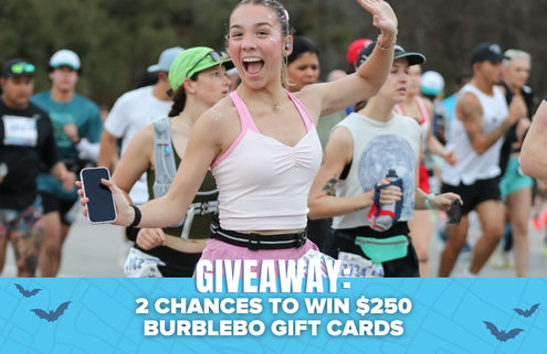 A smiling woman in athletic wear holds a phone and runs in a race with others, all hoping to win big. Text at the bottom reads, “GIVEAWAY: 2 CHANCES TO WIN $250 BURBLEBO GIFT CARDS.” Blue background has small bats, setting the scene for an exciting Neversecond Marathon Race Packs giveaway. Austin Marathon Half Marathon & 5K